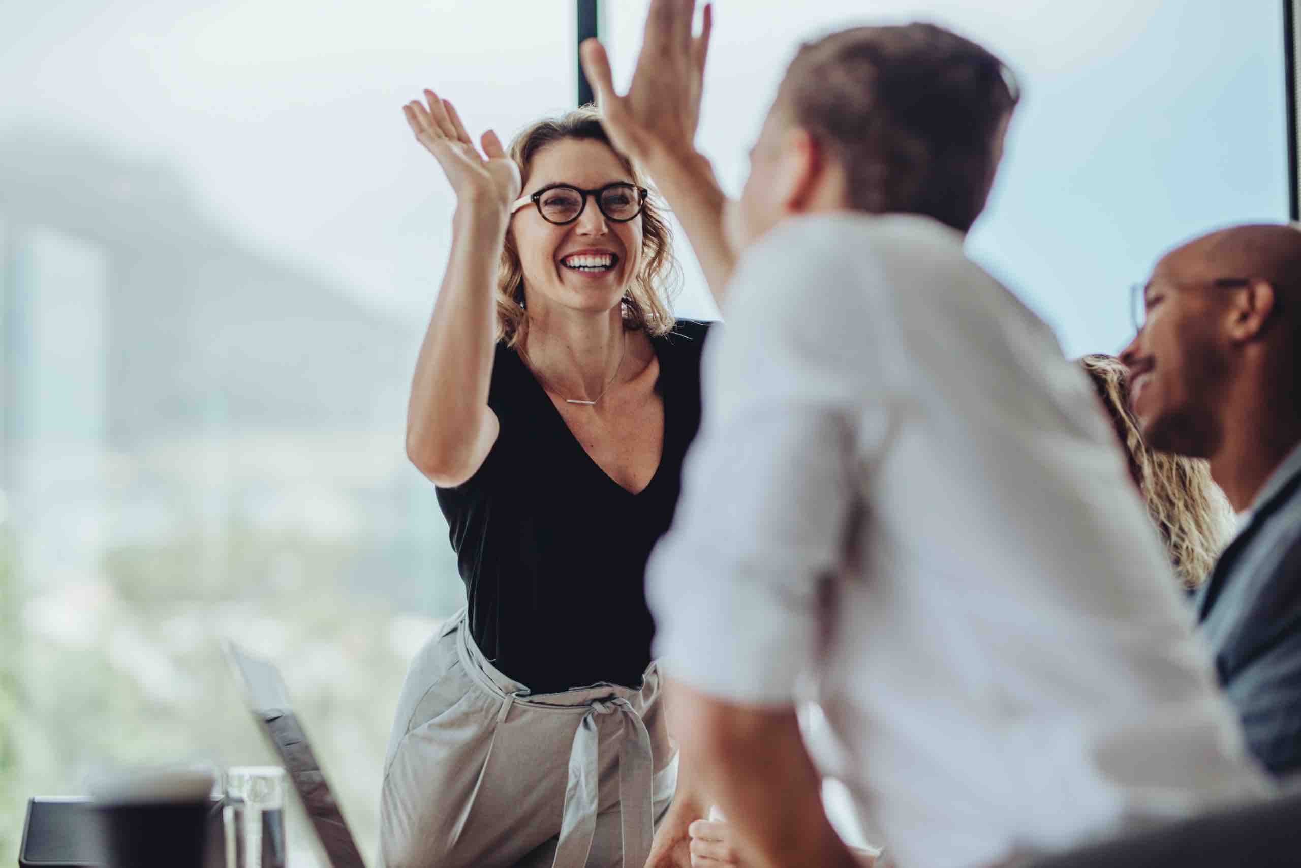 coworkers high five across desk