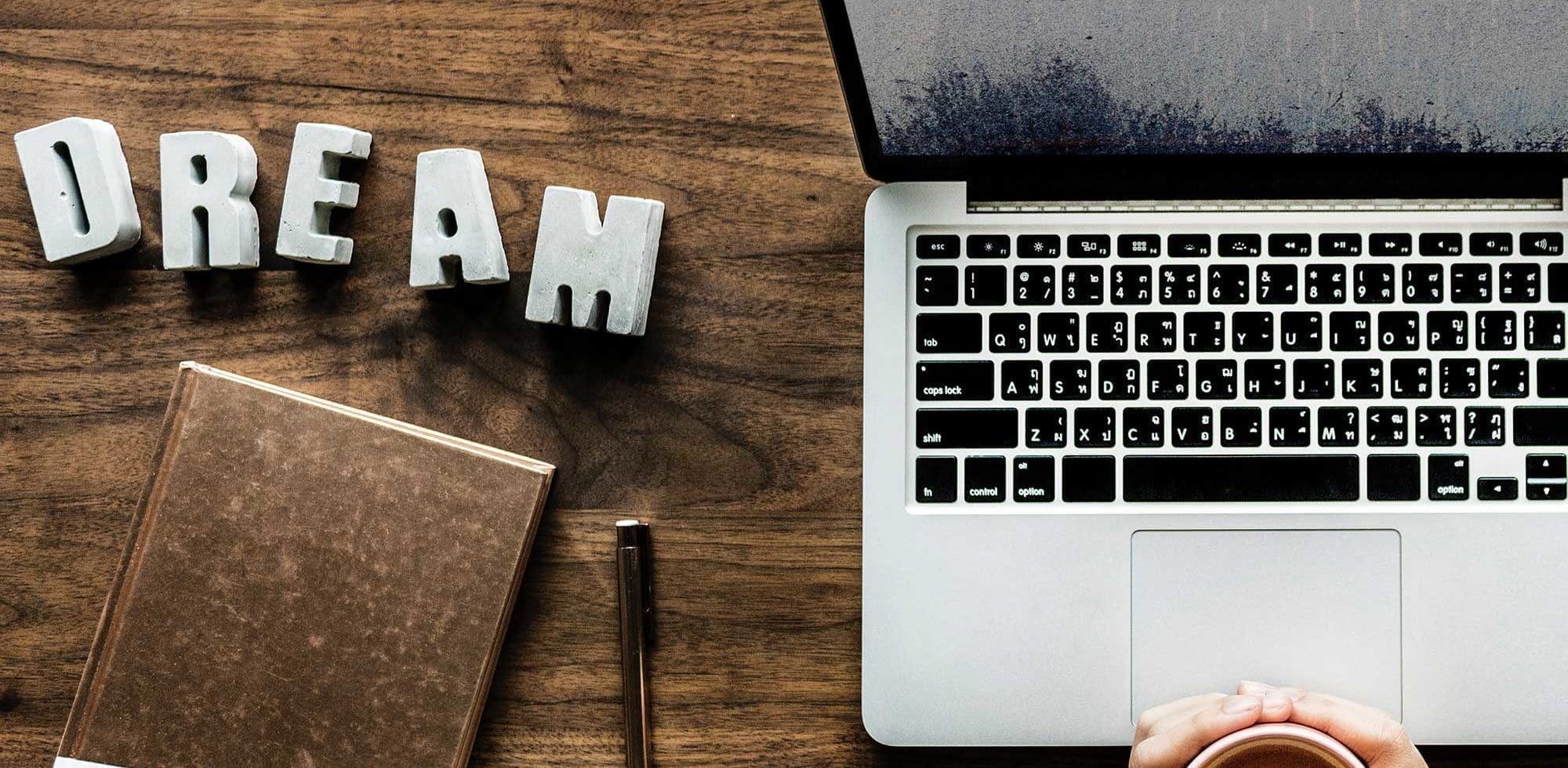 a laptop and notebook on top of the table