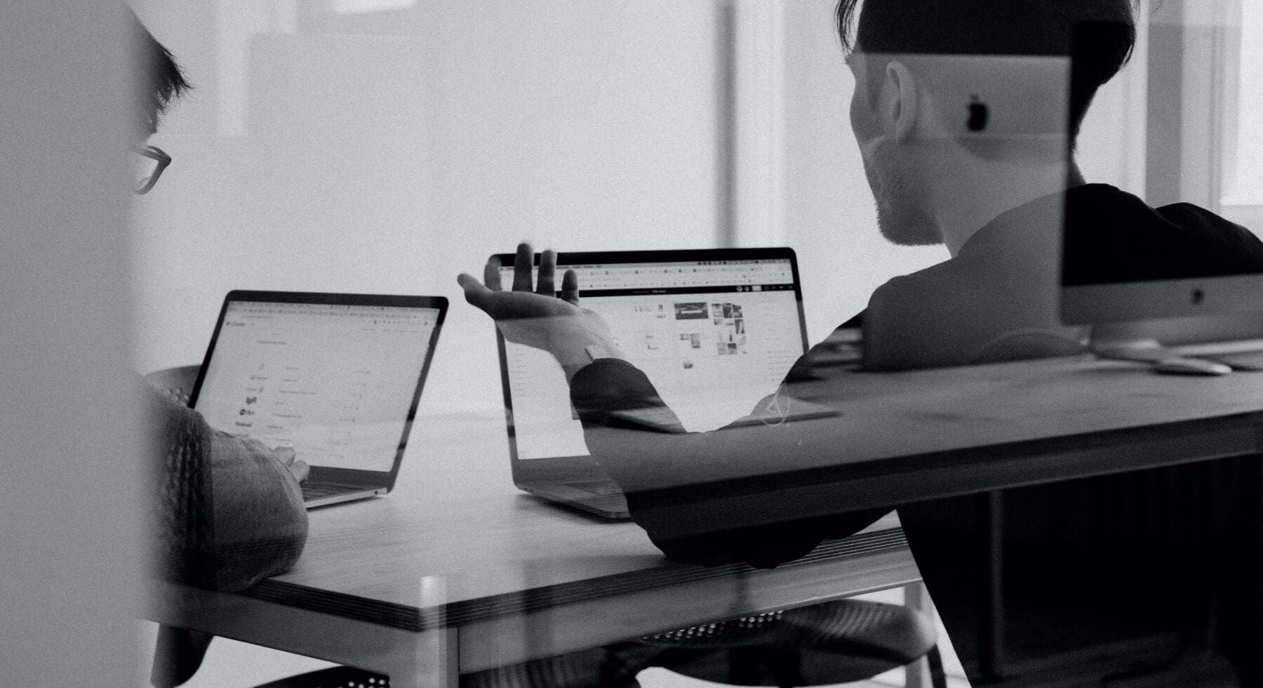 2 man talking with laptops