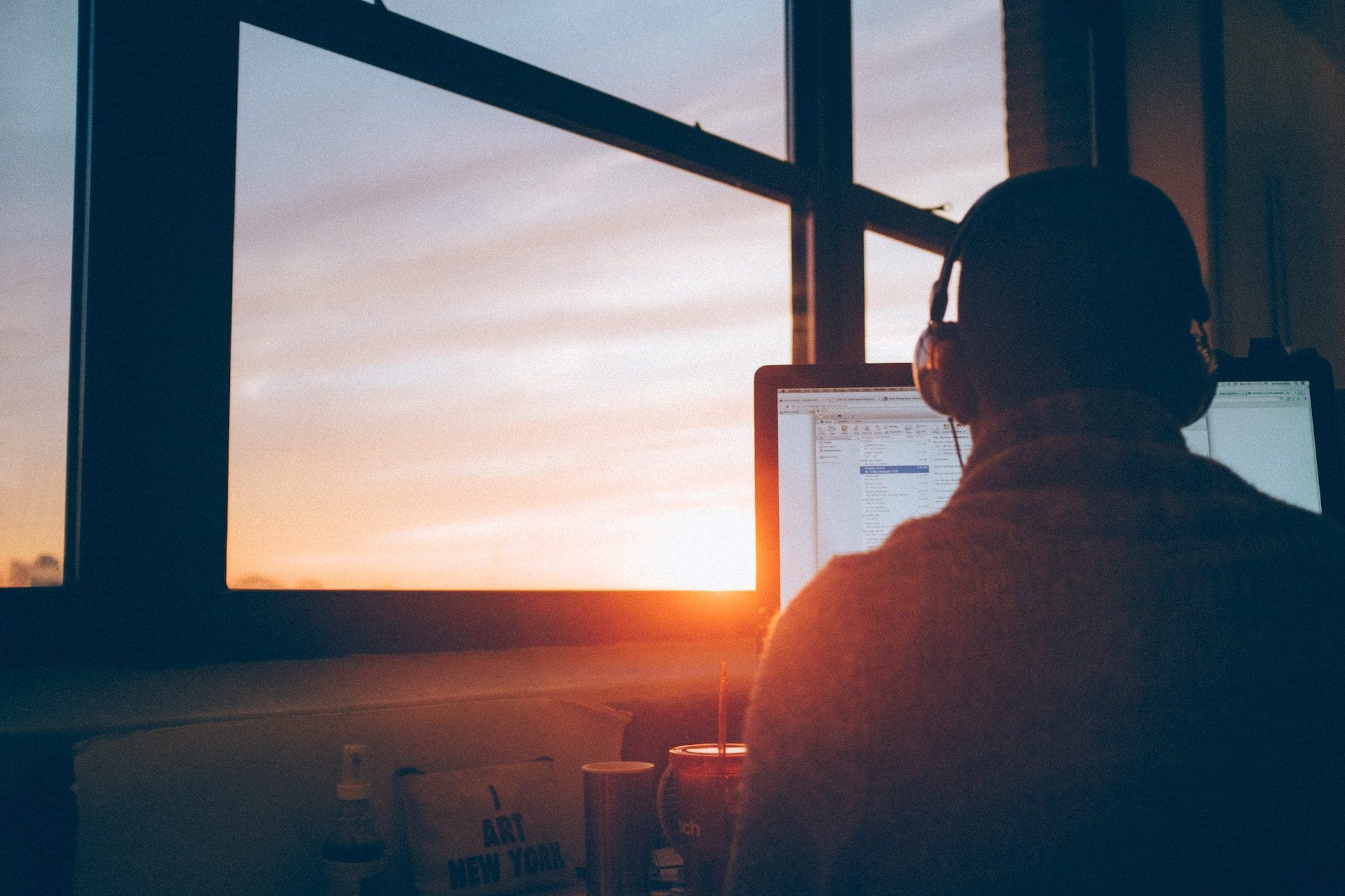 man sitting in front of computer near the window